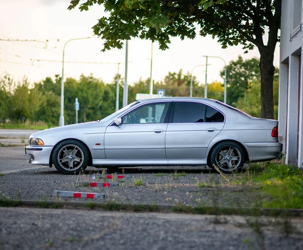 チェコ ブルノ 2023年8月13日 銀製の古い高級車が夕方には駐車場の外に立っています 木とガレージが付いている駐車場 — ストック写真