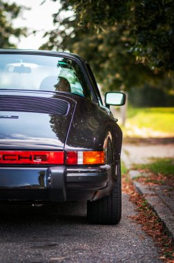 Brno, Çek Cumhuriyeti - 22 Ağustos 2023: 80 'lerden kalma eski siyah Porsche 911 spor arabası. Arkası ve ışığı detay.