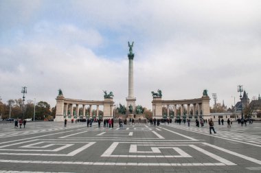 Budapeşte, Macaristan - 10 Ekim 2012: Yüksek kolonları ve heykelleri olan Kahramanlar Meydanı. Şehir merkezinde caddede insanlar var..