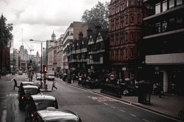 Londra, İngiltere - 18 Temmuz 2012: Şehir merkezinde eski evler ve otomobillerle dolu yollar. Metroya giriş ve cadde trafiği.