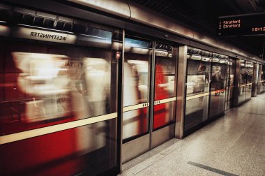 Londra, Birleşik Krallık - 18 Temmuz 2012: Bir yeraltı treni Westminster istasyonunda cam bir güvenlik duvarının arkasından hızla geçer.