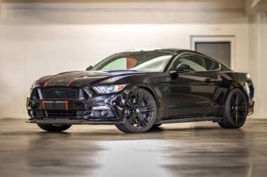Brno, Çek Cumhuriyeti - 12 Eylül 2023: Ford Mustang siyah çizgili spor spor kaslı araba. Hızlı bir araba garajda park halinde..