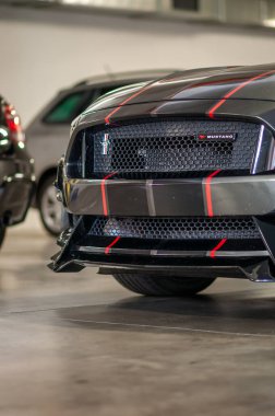 Brno, Çek Cumhuriyeti - 12 Eylül 2023: Siyah ve kırmızı folyodan yapılmış Ford Mustang bir arabanın ön tampon ve radyatörünün ayrıntıları.