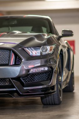 Brno, Çek Cumhuriyeti - 12 Eylül 2023: gri spor araba Ford Mustang. Ön ışık, sinyal ve tampon ayrıntıları. Hızlı ve kaslı bir araba garajda park halinde..
