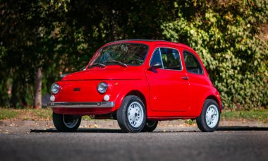 Kırmızı eski Fiat 500 sokağa park etmiş. Küçük İtalyan arabası, ön manzara..