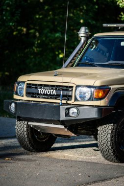 Brno, Çek Cumhuriyeti - 4 Ekim 2023: bej renkli Toyota arazi kruvazörü arazi aracı dışarıda, ormanda park halinde. Dışarıda güneşli doğada bir off-road arabası var..