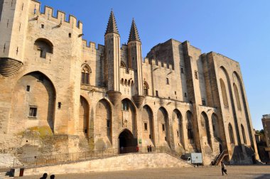 Avignon, Fransa - 29 Eylül 2011: Papalık Sarayı 'nın batan güneşle aydınlanan meydanı ile birlikte anıtsal binası.