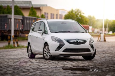 Aile beyaz Opel Zafira arabası eski tren istasyonunda. MPV tipi araba.