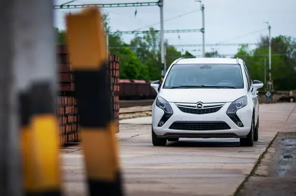 Aile beyaz Opel Zafira arabası eski tren istasyonunda. MPV tipi araba.