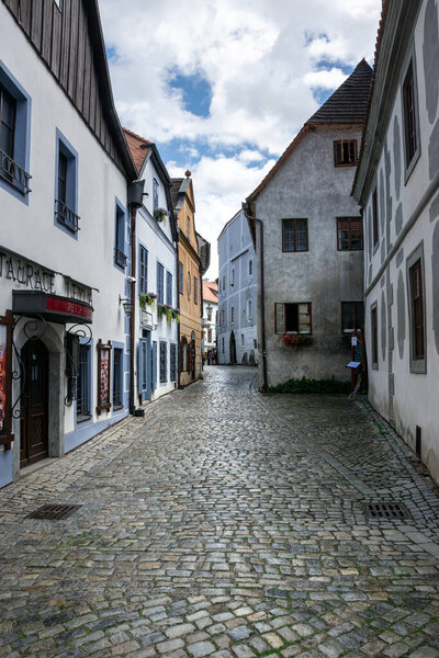 Cesky Krumlov, Czech Republic - July 30, 2023: Street in the city center with old houses and cobbled sidewalk.