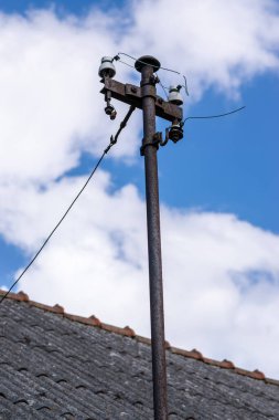 Evin çatısında elektrik hattı için demir deste var. Havada iletilen elektrik kabloları.