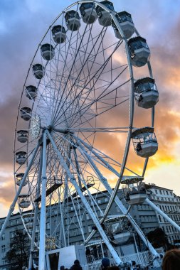 Brno, Czech Republic - 18 December 2023: Observation wheel for tourists in winter in the city center. Sunset with irradiated clouds.