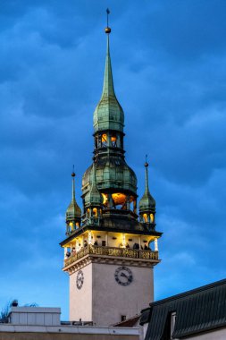 Brno, Czech Republic - 18 December 2023: The high tower of the old town hall as a lookout point for tourists in the city center. Illuminated old building in the evening before dusk.