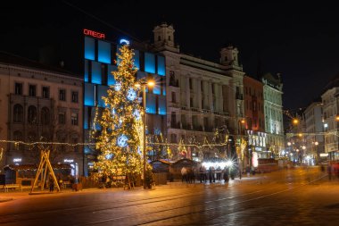 Brno, Czech Republic - 20 December 2023: Main square in night city at Christmas with decorated Christmas tree. Decorations, bulbs and illuminated streets on Freedom Square.