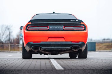 Brno, Çek Cumhuriyeti - 31 Aralık 2023: Otoparka kırmızı bir Dodge Challenger park etti. Hızlı lüks spor araba. Amerikan kaslı arabasının arka camı ve ışıkları.
