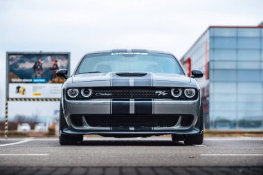 Brno, Çek Cumhuriyeti - 31 Aralık 2023: Otoparka gri bir Dodge Challenger park etti. Hızlı lüks spor araba. Amerikan kaslı arabasının ön ızgara ve ışık manzarası.