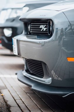 Brno, Çek Cumhuriyeti - 31 Aralık 2023: Otoparka gri bir Dodge Challenger park etti. Hızlı lüks spor araba. Amerikan kaslı arabası ön ve ön far detayı.