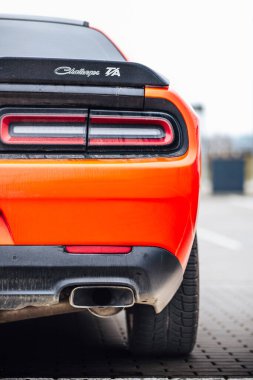 Brno, Çek Cumhuriyeti - 31 Aralık 2023: Otoparka kırmızı bir Dodge Challenger park etti. Hızlı lüks spor araba. Amerikan kaslı araba stop lambası detayı.