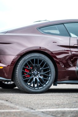 Brno, Çek Cumhuriyeti - 31 Aralık 2023: koyu kırmızı Ford Mustang, hızlı Amerikan spor arabası. Tekerlekli siyah tekerleğin ayrıntıları.