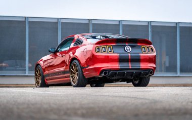 Brno, Çek Cumhuriyeti - 31 Aralık 2023: Siyah folyo hızlı şeritli kırmızı hızlı spor bir Ford Mustang bir otoparka park edilmiştir. Arabanın arka görüntüsü..