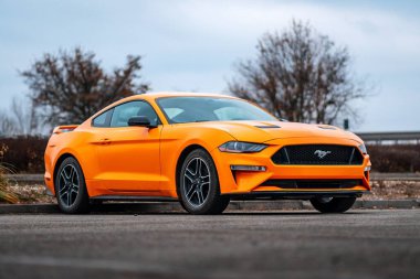 Brno, Çek Cumhuriyeti - 31 Aralık 2023: Sarı hızlı spor bir Ford Mustang dışarıda asfalt bir otoparkta duruyor. Ön tarafta radyatör ızgarası ve tampon var..