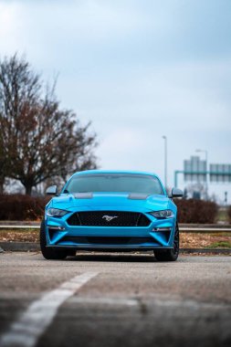 Brno, Çek Cumhuriyeti - 31 Aralık 2023: Mavi hızlı bir Ford Mustang dışarıda asfalt bir otoparkta duruyor. Ön tarafta radyatör ızgarası ve tampon var..