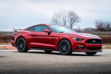 Brno, Çek Cumhuriyeti - 31 Aralık 2023: Kırmızı hızlı spor Ford Mustang asfalt bir otoparkta duruyor.