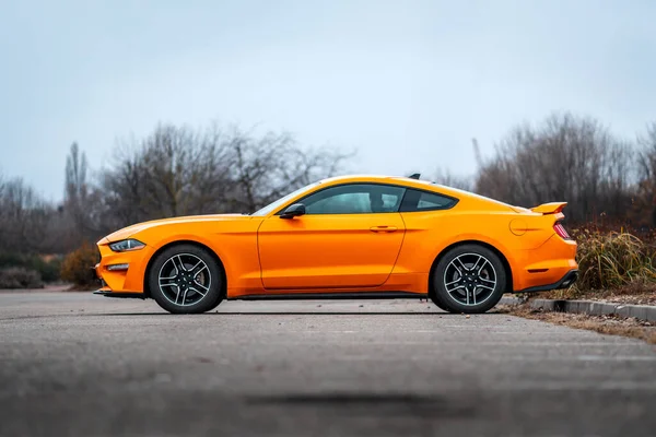 Brno, Çek Cumhuriyeti - 31 Aralık 2023: Sarı hızlı spor bir Ford Mustang dışarıda asfalt bir otoparkta duruyor. Arabanın yan tarafına bak..