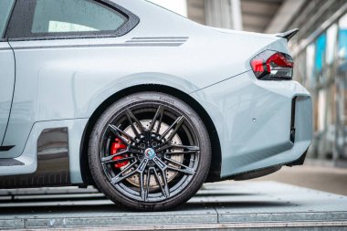 Brno, Çek Cumhuriyeti - 25 Kasım 2023: hafif araba, siyah frenli tekerlek ve BMW M2 spor arabasının kanadı. Gri spor sedan.