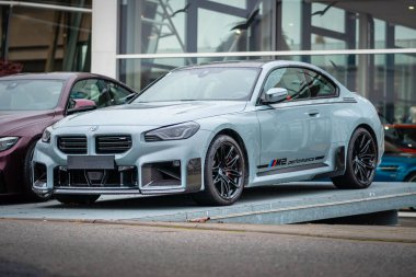 Brno, Çek Cumhuriyeti - 25 Kasım 2023: BMW M2 spor arabasının görüntüsü. Siyah tekerlekleri, çıkartmaları ve kırmızı frenleri olan gri bir sedan..