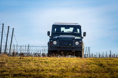 Güney Moravya, Çek Cumhuriyeti - 06 Ocak 2024: Land Rover Defender bir üzüm bağındaki çimenli bir çayır üzerine park etti.