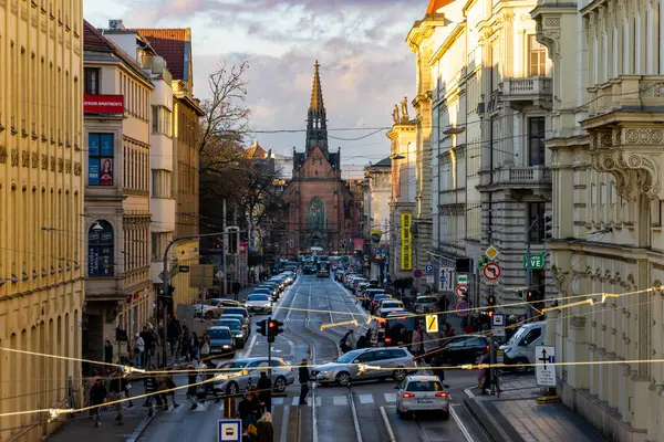 Brno, Çek Cumhuriyeti - 21 Aralık 2023: Gün batımında şehir merkezinde. Şehirdeki bir kavşakta insanlarla dolu bir sıra araba ve yoğun trafik..