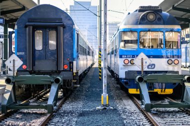 Brno, Çek Cumhuriyeti - 18 Mart 2024: Platformun yanındaki tren istasyonunda mavi beyaz bir lokomotif duruyor. Şehirdeki bir istasyonda yolcu bekleyen bir tren..