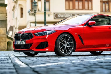 Brno, Çek Cumhuriyeti - 28 Mart 2024: Pahalı spor lüks kırmızı BMW M8 arabası caddenin dışındaki şehir merkezine park edilmiştir. Bir araba parçasının ayrıntıları.