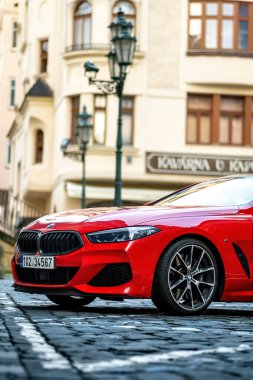 Brno, Çek Cumhuriyeti - 28 Mart 2024: Pahalı spor lüks kırmızı BMW M8 arabası caddenin dışındaki şehir merkezine park edilmiştir. Ön tekerlek ayrıntıları.