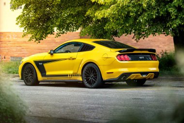 Brno, Çek Cumhuriyeti - 3 Mayıs 2024: Sarı spor araba Ford Mustang caddenin dışında. Arabanın arka ve yan görüntüsü..