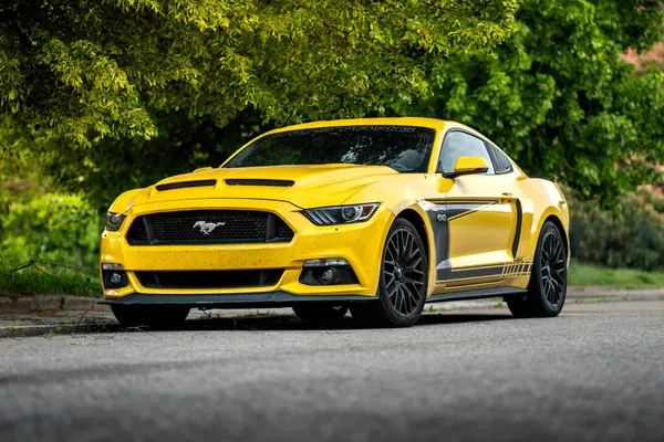 Brno, Çek Cumhuriyeti - 3 Mayıs 2024: Sarı spor araba Ford Mustang caddenin dışında. Arabanın ön ve yan görüntüsü..