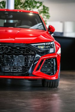 Brno, Çek Cumhuriyeti - 21 Mart 2024: Araba galerisindeki bir satıcıda kırmızı lüks bir Audi arabasının ön ışığı ve ızgarası.