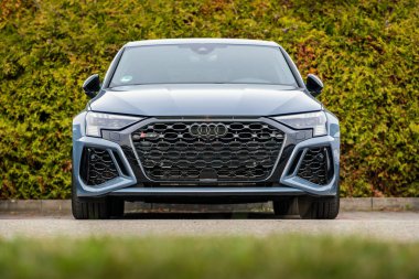 Brno, Çek Cumhuriyeti - 21 Mart 2024: Grili bir Audi RS3 spor arabası bir çalılığın önündeki otoparkta park halinde..