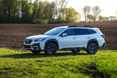 Brno, Çek Cumhuriyeti - 20 Nisan 2024: Beyaz off-road Subaru Outback doğada bir direğin üzerinde duruyor. SUV doğada park halinde..