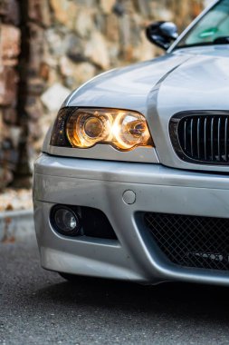 Sobeslav, Çek Cumhuriyeti - 10 Temmuz 2024: Açık havada klasik bir BMW 3 serisinin ön LED ışığının ayrıntıları. Gümüş renkli spor bir arabanın arkası..