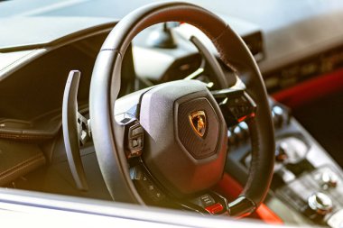 Brno, Çek Cumhuriyeti - 24 Eylül 2024: Direksiyon simidi ve Lamborghini spor arabasının kontrolü. Lüks bir arabanın iç kısmının ayrıntıları..