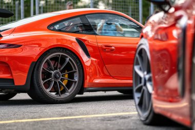 Brno, Çek Cumhuriyeti - 24 Eylül 2024: Kırmızı bir Porsche 911 dışarıda bir otoparkta duruyor. Arabanın ve direksiyonun ayrıntıları..