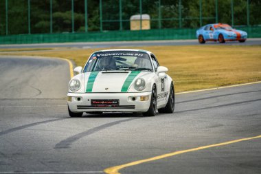 Brno, Çek Cumhuriyeti - 24 Eylül 2024: Beyaz yarış Porsche 911 pistte turluyor. Eski spor araba rayına oturdu..