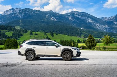 Schladming, Avusturya - 22 Ağustos 2024: Dağlardaki bir otoparkta beyaz aile SUV Subaru Outback. Avusturya Alpleri ile 4x4 'lük bir yolculuk..