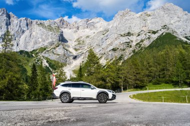 Dachstein, Avusturya - 22 Ağustos 2024: Avusturya Alplerinde Japon arabası Subaru Outback. Dachstein Dağları 'nın aşağısındaki otoparkta beyaz bir SUV..