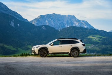 Schladming, Avusturya - 22 Ağustos 2024: Dağlardaki bir otoparkta beyaz aile SUV Subaru Outback. Avusturya Alpleri ile 4x4 'lük bir yolculuk..