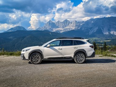 Schladming, Avusturya - 22 Ağustos 2024: Dağlardaki bir otoparkta beyaz aile SUV Subaru Outback. Avusturya Alpleri ile 4x4 'lük bir yolculuk..