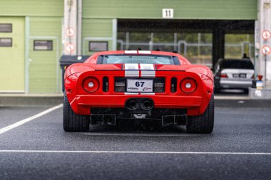 Brno, Çek Cumhuriyeti - 24 Eylül 2024: Kırmızı Ford GT yarış süper arabası garajların önünde park halinde. Lüks pahalı spor araba..