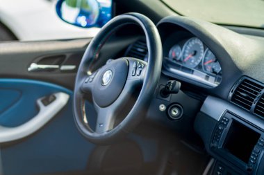 Brno, Çek Cumhuriyeti - 15 Ekim 2024: Eski bir BMW M3 arabasının içi, direksiyon ve gösterge paneli kontrolleri ve düğmeleri.